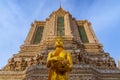 Golden statue of standing Buddha with bowl and ornated temple on the background Royalty Free Stock Photo