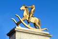 Golden statue of young child on rocking horse