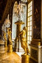 Golden statues stand in a grand marble hall at the historic Versailles Palace in France Royalty Free Stock Photo