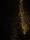 Golden stream of spices in frozen flight on a black background. Aromatic additives, seasonings, spices. Cooking, oriental cuisine