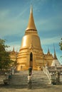 Golden stupa couple persons taking a photo portrait at Temple of the Emerald Buddha Grand Palace complex in Bangkok Thailand Royalty Free Stock Photo