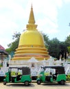 Golden stupa and two tuk tuks
