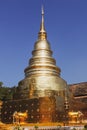 Golden stupa at Wat Phra Singh in Chinag Mai, Thailand against a clear blue sky