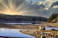 golden sun beams from sunset over hill and sea Royalty Free Stock Photo