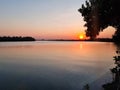 golden sun light sunset in water lake behind island. silhouette tree on beach romantic place in thailand Royalty Free Stock Photo