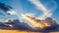 Golden Sun Rays Breaking Through Dramatic Cumulus Clouds at Sunset with Vibrant Orange Sky Royalty Free Stock Photo