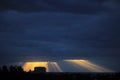 Golden sun rays bursting through the dark blue clouds Royalty Free Stock Photo