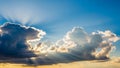Dramatic sun rays bursting through dark clouds against a bright blue sky with golden light Keywords: sun, rays Royalty Free Stock Photo