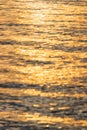 Golden sunlight reflection on rippled water surface creating warm shimmering pattern Royalty Free Stock Photo