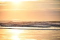 Golden sunrise in the early morning by the ocean. Waves and sandy beach. Royalty Free Stock Photo
