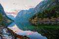 Golden sunrise in the mountains, Gudvangen Norway with reflection in the water of the fjord. Royalty Free Stock Photo