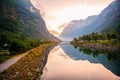 Golden sunrise in the mountains, Gudvangen Norway with reflection in the water of the fjord. The horizontal frame. Royalty Free Stock Photo