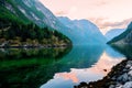 Golden sunrise in the mountains Gudvangen Norway in the summer with the reflection of clouds and trees in the water fjord. Royalty Free Stock Photo