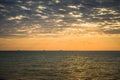 Golden sunrise at the sea on a cloudy morning. Ships can be seen against the background of sunrise on the horizon. A flock of Royalty Free Stock Photo