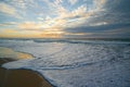 Golden sunset on the beach and low sea waves brake the shore. Royalty Free Stock Photo