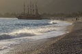 Golden sunset on the beach of the Mediterranean Sea. A yacht is moored at the shore Royalty Free Stock Photo