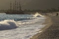 Golden sunset on the beach of the Mediterranean Sea. A yacht is moored at the shore Royalty Free Stock Photo