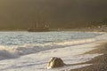 Golden sunset on the beach of the Mediterranean Sea. A yacht is moored at the shore Royalty Free Stock Photo