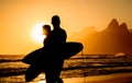 Golden sunset in Ipanema Beach and two surfers silhouettes Royalty Free Stock Photo