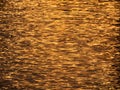 Golden sunset light reflection in dark evening water - purposely blurred and textured background Royalty Free Stock Photo