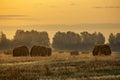 Golden sunset over farm field with hay bales. Autumn landscape Royalty Free Stock Photo