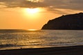 Golden sunset over the Mediterranean Sea. The setting sun shines through the clouds, and a golden path is visible above the ocean Royalty Free Stock Photo