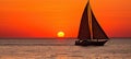 Golden Sunset over Ocean with Sailboat on Horizon, Magnifying Grandeur and Tranquility Royalty Free Stock Photo