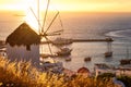 Golden sunset over sea horizon in Mykonos, Greece. Famous traditional white windmill on hot summer evening in sunlight Royalty Free Stock Photo