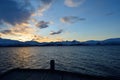 Golden sunset over snowy mountain with reflection on fjord Royalty Free Stock Photo