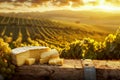 Golden Sunset Over Vineyard with Cheese Platter on Wooden Table Amidst Rolling Hills of Grapevines Royalty Free Stock Photo