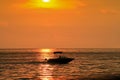 Golden sunset photo with a silhouette of a speed boat
