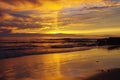 Golden sunset reflected in clouds and wet sand, Pacific Ocean near San Diego, CA