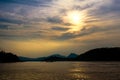 Golden sunset on a river under fluffy clouds