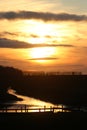 Golden sunset, stream, silhouettes trees, fence