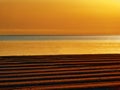 Golden sunset or sunrise on racked beach panorama.