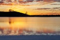 Golden sunset with tree silhouettes blurred water reflections