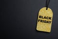 Golden tag with words Black Friday on dark background, top view. Space for text Royalty Free Stock Photo
