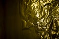 Golden texture. Background of gold film. Bright reflection in thin metal sheet. Overflow of waves