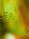 Golden texture with green shades. Rough metal surface with a beautiful pattern. Yellow abstraction.