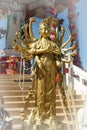 Beautiful Golden Thousand-hand Guan Yin statue stands in front of the pavilion