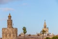 Golden tower Torre del Oro and Giralda tower of seville cathedral at sunset from the other side of the Guadalquivir river, Royalty Free Stock Photo