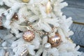 Golden toy decorations on a white artificial Christmas tree. Shao beads ornaments hanging on the branches of eco-friendly fir, new Royalty Free Stock Photo