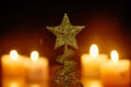 golden tree top star decoration in Christmas and new year festival with candle light on black background Royalty Free Stock Photo