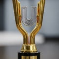 A golden trophy with an abstract design featuring two upward-arching branches Royalty Free Stock Photo