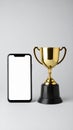 Golden Trophy Cup Next to Mobile Phone Mockup Displaying Blank Screen on Simple Background Royalty Free Stock Photo
