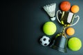 Golden trophy, Football toy, Baseball toy, Ping pong ball, Shuttlecock and Tennis isolated on black background with copy Royalty Free Stock Photo