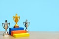 Golden trophy standing on colorful podium with two silver trophy