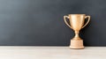 Golden trophy on wooden table against dark background Royalty Free Stock Photo