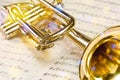 Golden trumpet on sheet music with scenic reflections and lens flare Royalty Free Stock Photo