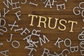 Golden trust text and steel alphabet on wooden board 3D illustration